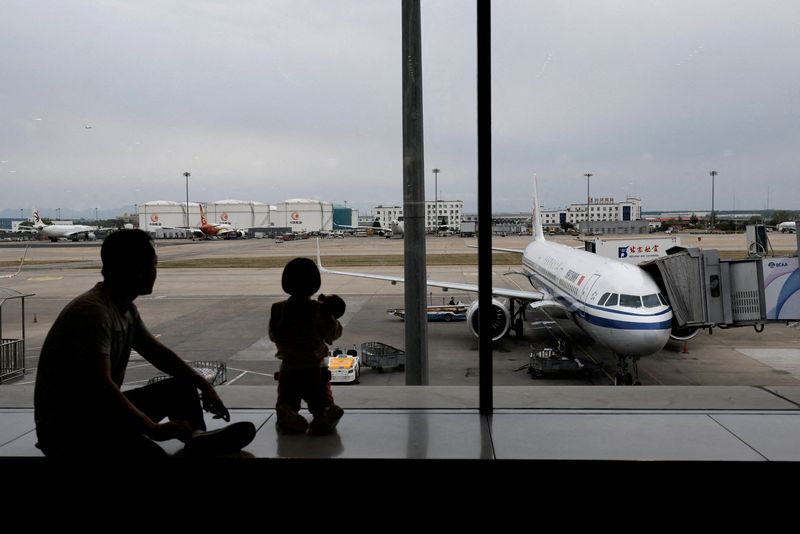 © Reuters. FILE PHOTO: Passengers look at the tarmac as they wait for their flights at the Beijing Capital International Airport, in Beijing, China April 20, 2024. REUTERS/Tingshu Wang/File Photo