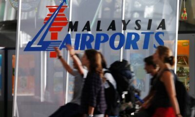 © Reuters. FILE PHOTO: Travellers push their trolley past a logo of Malaysia Airports at the departure hall of Kuala Lumpur International Airport in Sepang, outside Kuala Lumpur August 26, 2013. REUTERS/Bazuki Muhammad/File Photo