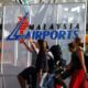 © Reuters. FILE PHOTO: Travellers push their trolley past a logo of Malaysia Airports at the departure hall of Kuala Lumpur International Airport in Sepang, outside Kuala Lumpur August 26, 2013. REUTERS/Bazuki Muhammad/File Photo