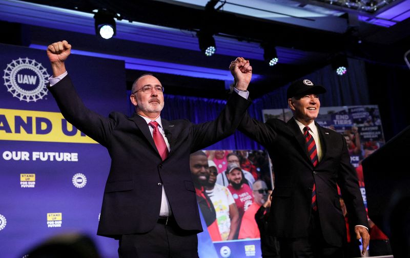 © Reuters. FILE PHOTO: U.S. President Joe Biden holds hands with United Auto Workers (UAW) President Shawn Fain after Fain and the UAW endorsed Biden for president prior to Biden's remarks at their Community Action Program (CAP) legislative conference in Washington, U.S., January 24, 2024. REUTERS/Leah Millis/File Photo