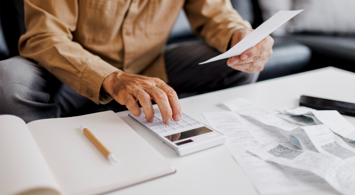 A man calculating capital gains tax and income tax obligations.