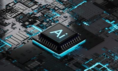 A black and teal AI chip on a black and teal motherboard.