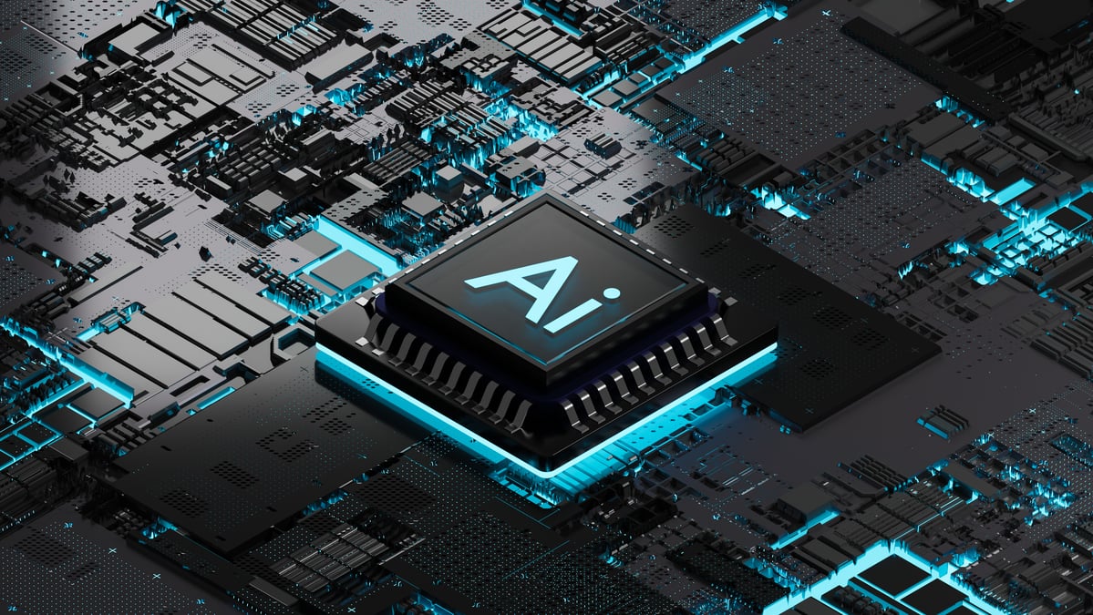 A black and teal AI chip on a black and teal motherboard.