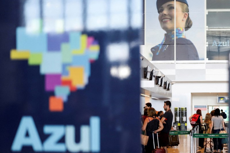 © Reuters. FILE PHOTO: Passengers stand near a Brazilian airline Azul signage at Viracopos International Airport, in Campinas, Sao Paulo State, Brazil, March 16, 2020. REUTERS/Rahel Patrasso/File Photo