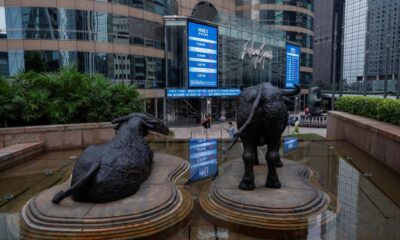 © Reuters. FILE PHOTO: Bull statues are placed in font of screens showing the Hang Seng stock index and stock prices outside Exchange Square, in Hong Kong, China, August 18, 2023. REUTERS/Tyrone Siu/File Photo