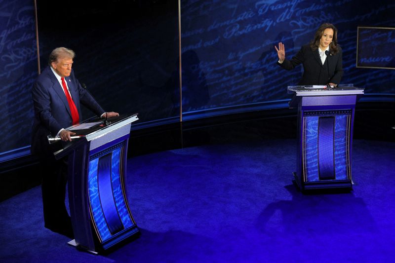 © Reuters. FILE PHOTO: Democratic presidential nominee, U.S. Vice President Kamala Harris speaks during a presidential debate hosted by ABC as Republican presidential nominee, former U.S. President Donald Trump listens, in Philadelphia, Pennsylvania, U.S., September 10, 2024. REUTERS/Brian Snyder/File Photo