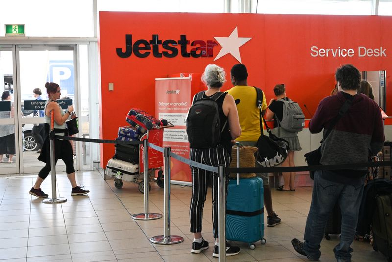 © Reuters. FILE PHOTO: Travelers wait in line at a Jetstar Airways counter at Kingsford Smith International Airport, in Sydney, Australia, March 18, 2020. REUTERS/Loren Elliott/ File Photo