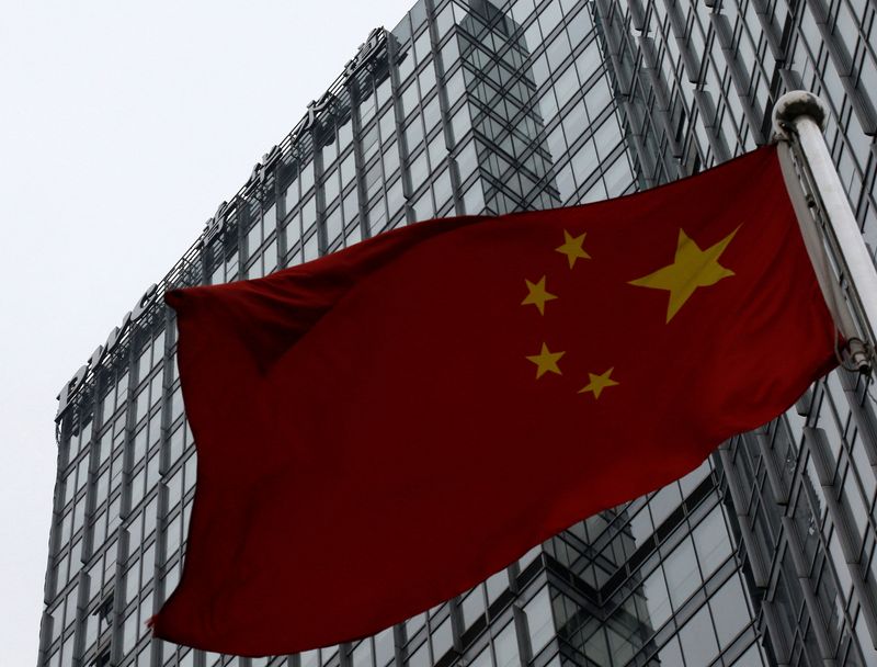 © Reuters. FILE PHOTO: A building housing the PricewaterhouseCoopers (PWC) branch office stands behind a Chinese national flag in Beijing January 24, 2014.  REUTERS/Kim Kyung-Hoon/File Photo