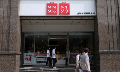 © Reuters. FILE PHOTO: People walk past a store of Chinese retailer MINISO Group in Beijing, China September 13, 2021. REUTERS/Tingshu Wang/File Photo