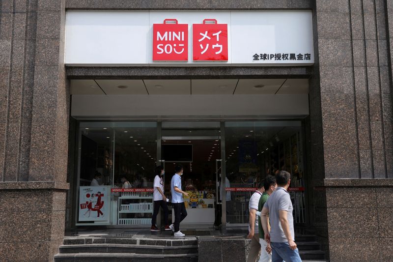 © Reuters. FILE PHOTO: People walk past a store of Chinese retailer MINISO Group in Beijing, China September 13, 2021. REUTERS/Tingshu Wang/File Photo