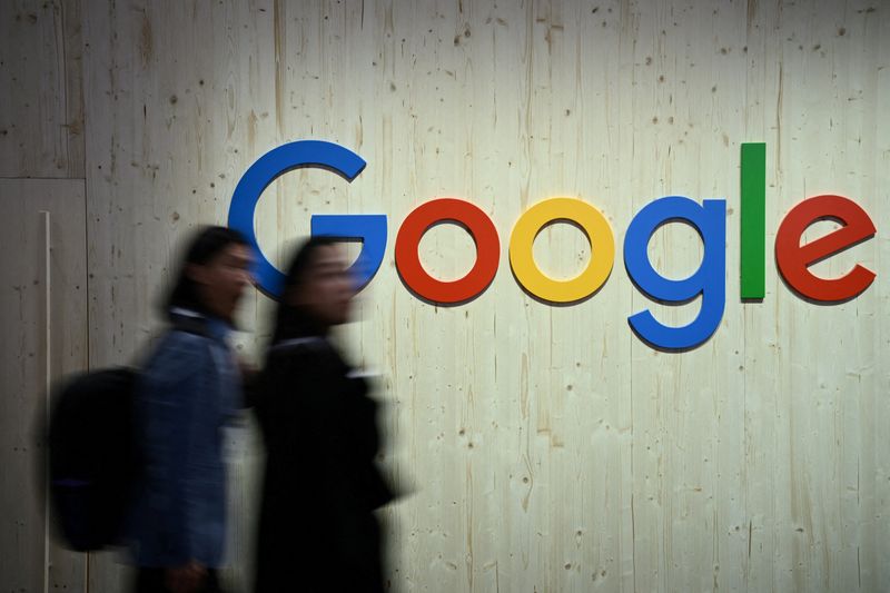 © Reuters. FILE PHOTO: People walk next to a Google logo during a trade fair in Hannover Messe, in Hanover, Germany, April 22, 2024.  REUTERS/Annegret Hilse/File Photo