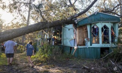 © Reuters. Nash Harris and his mother Alicia walk towards the home where they had been living to try and find some salvageable clothing after Hurricane Helene made landfall in Steinhatchee, Florida, U.S., September 27, 2024. REUTERS/Kathleen Flynn